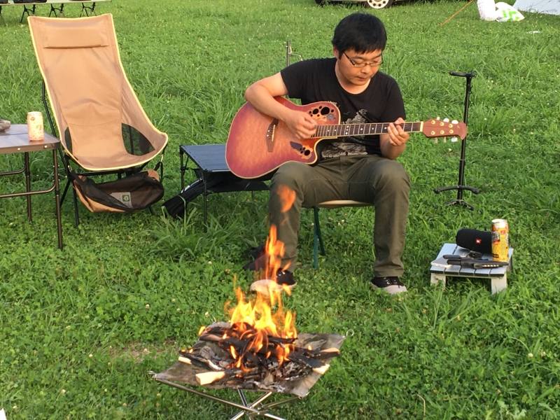 ソロソロキャンプにて。ギターを弾く佐藤さんの写真