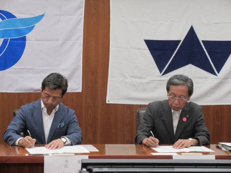 協定書に署名をする菊池市長と大野城市長の写真