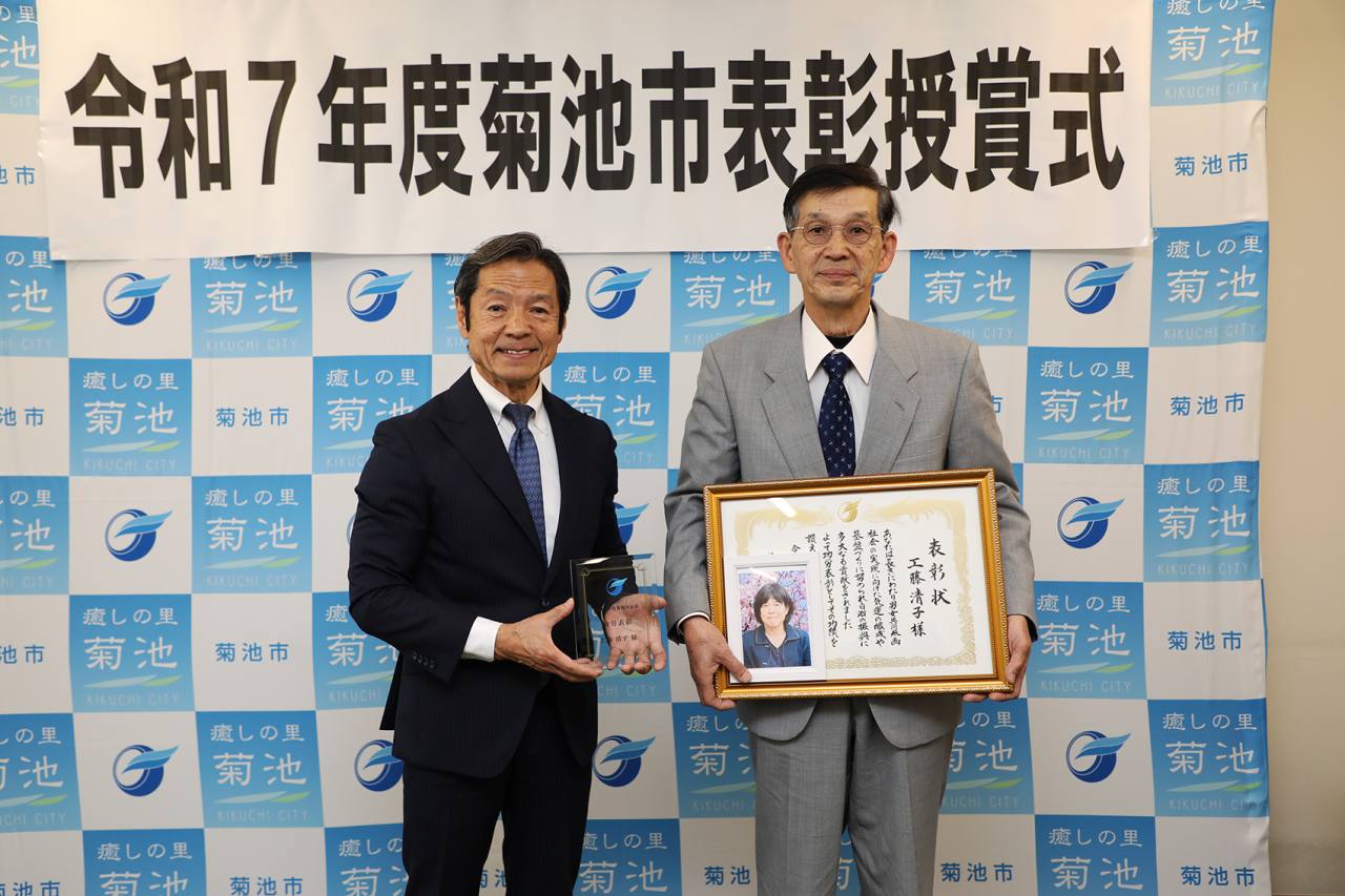 表彰状を持つ工藤健正さん（右）
