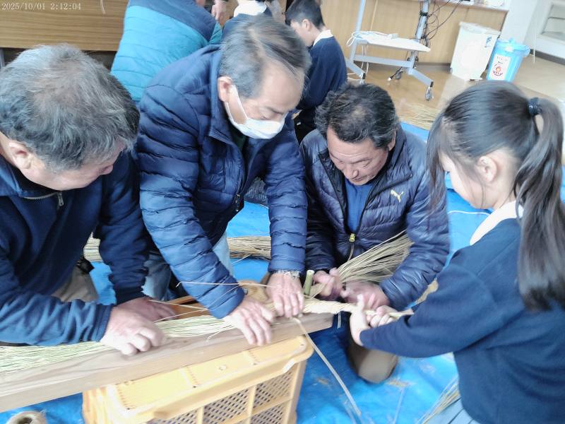 区長さんとしめ縄を作る子ども