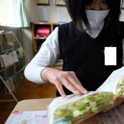 たくさんの付箋がついた辞書を持つ児童の画像